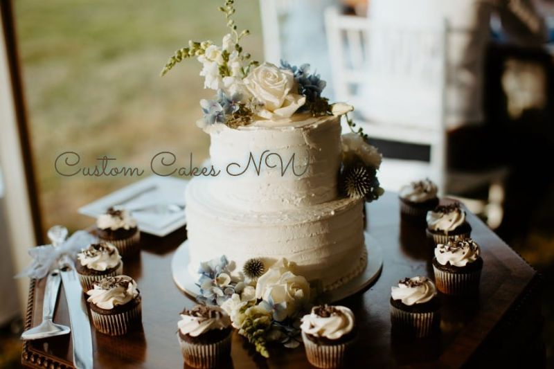 Custom Cakes NW cream wedding cake with floral display and chocolate sprinkle cupcakes